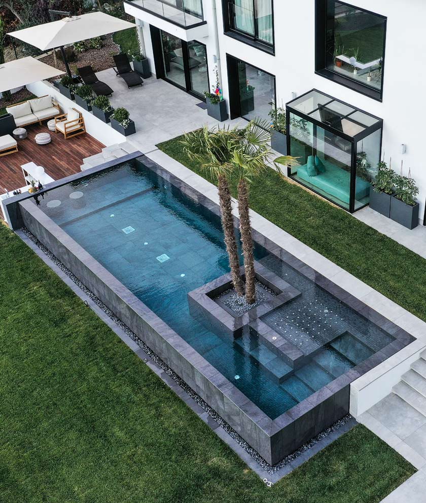 particolare di una piscina realizzata a catanzaro da silpa con colore cristallino, natura con alberi e mobilia dedicata